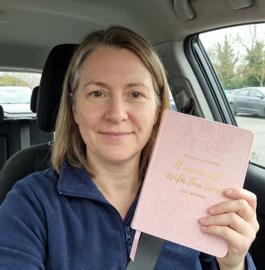 Customer photo: woman with the devotional at her kitchen table