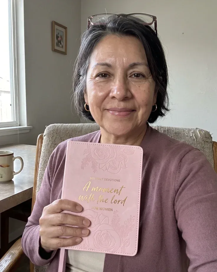 Customer photo: woman reading the open devotional on a sofa